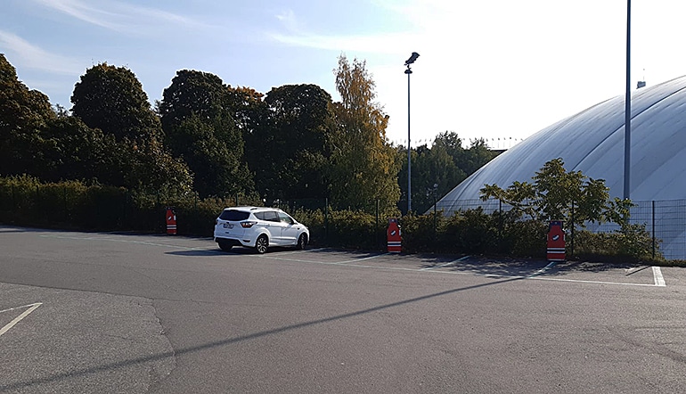 P-Helsingin jäähalli, yksityiskohta pysäköintialueelta, jossa yksi auto ja sähköautojen latauspaikkoja