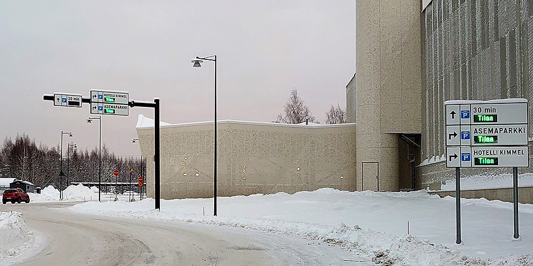 P-Asemaparkki Joensuu, näkymä ajettaessa kohti parkkirakennusta ja kyltti, jossa kerrotaan onko pysäköintitalossa tilaa