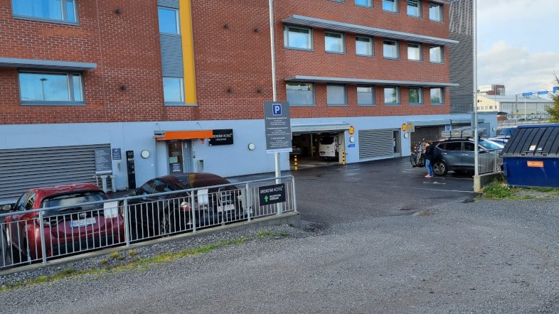 P-GreenStar Hotel Vaasa, autoja pihan pysäköintipaikoilla ja sisäänkäynti parkkihalliin