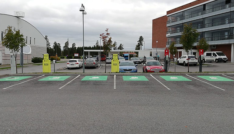 P-Katinkulta Sotkamo, sähköautojen latauspisteitä parkkipaikalla merkittynä vihreällä ja taustalla hotellin rakennuksia