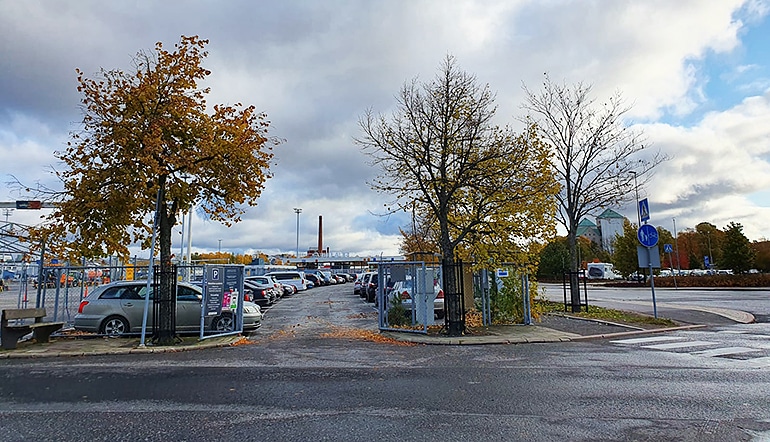 P-Linnankatu 91 Turku, autoja asfaltoidulla ja aidatulla parkkipaikalla terminaalin vieressä, taustalla Turun linna