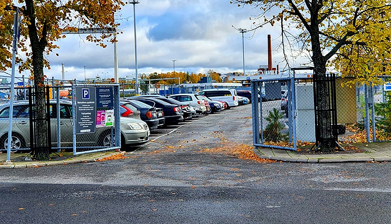 P-Linnankatu 91 Turku, autoja asfaltoidulla parkkialueella jonka taustalla näkyy laivaterminaali