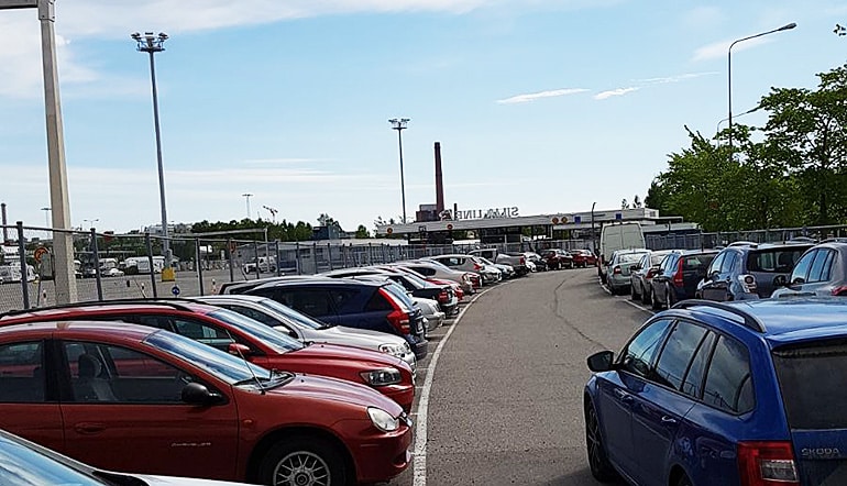 P-Linnankatu 91 Turku, autoja asfaltoidulla ja aidatulla pysäköintipaikalla jonka taustalla näkyy Silja Linen terminaali