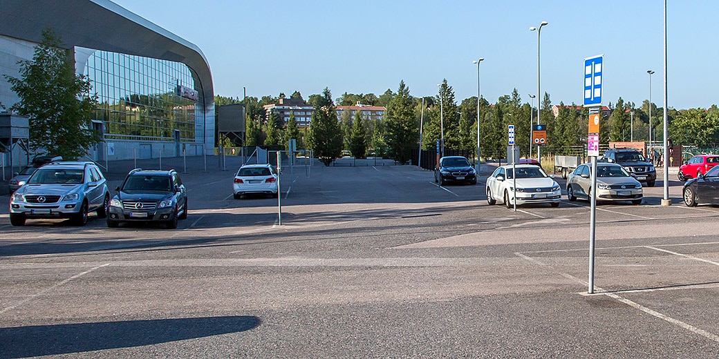 P-Messukeskus Siipi Helsinki, yleiskuva parkkipaikasta, vasemmalla Messukeskuksen rakennus ja taustalla puita sekä kerrostaloja