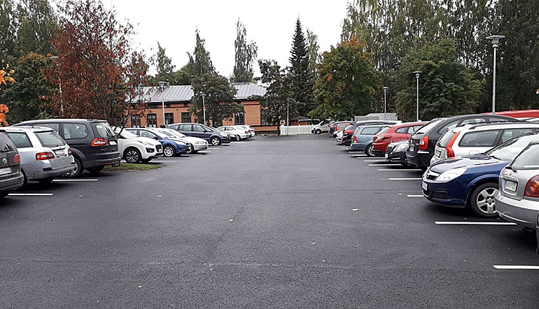 P-Oikeus ja poliisitalo Kuopio, autoja puiden ympäröimällä parkkipaikalla