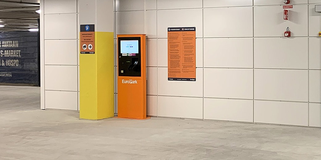 P-Raatikeskus Kajaani, maksuautomaatti ja ohjekyltti seinustalla pysäköintihallin sisällä