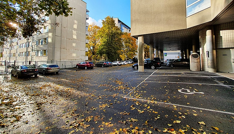 P-Scandic Atrium Turku, asfaltoitu parkkialue suojaisalla sisäpihalla, jossa osa paikoista on katettu ja kuvassa näkyy myös liikkumisesteisen pysäköintipaikka
