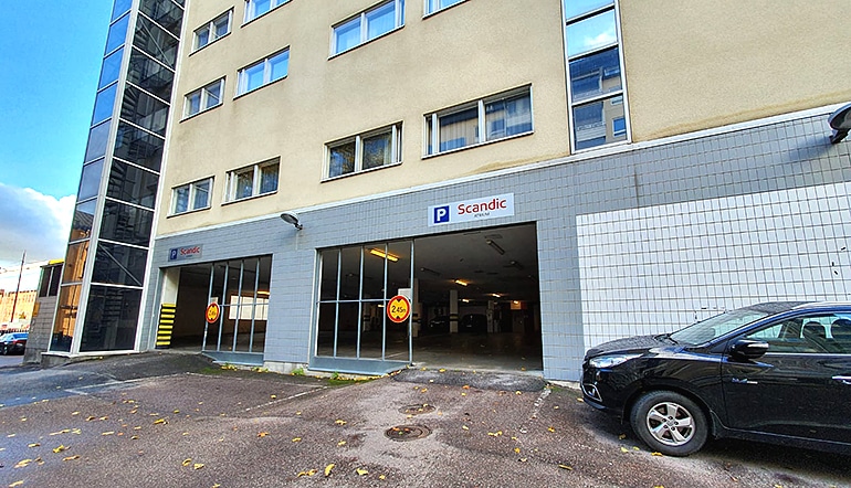 P-Scandic Atrium Turku, katettu parkkipaikka hotellin seinustalla kadulta katsottuna