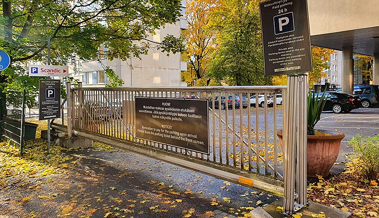 P-Scandic Atrium Turku, parkkipaikan sisäänajon portti puiden ja rakennusten keskellä