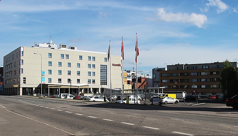 P-Scandic Rovaniemi, näkymä hotellille ja sen pihalla olevalle asfaltoidulle parkkipaikalle