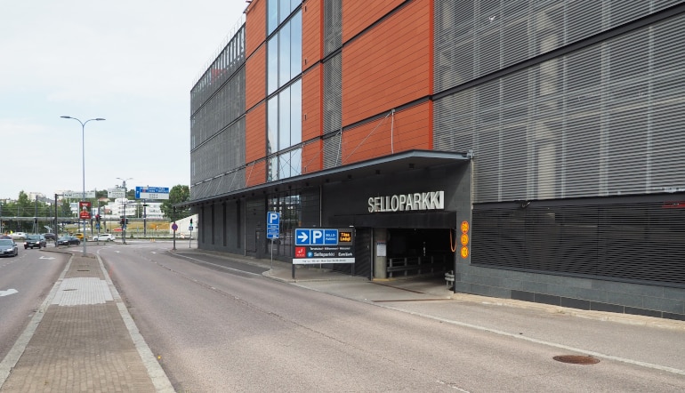 P-Selloparkki Espoo, parkkihallin sisäänajo liiketilarakennuksen seinässä kadulta katsottuna