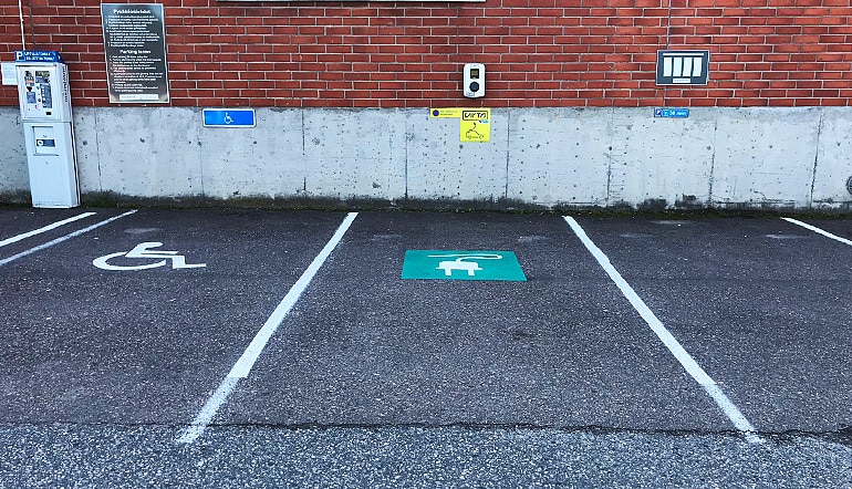 P-Valimotie 25-27 Helsinki, yksityiskohta pysäköintialueelta, jossa näkyy sähköautojen latauspaikka ja liikkumisesteisen pysäköintipaikka