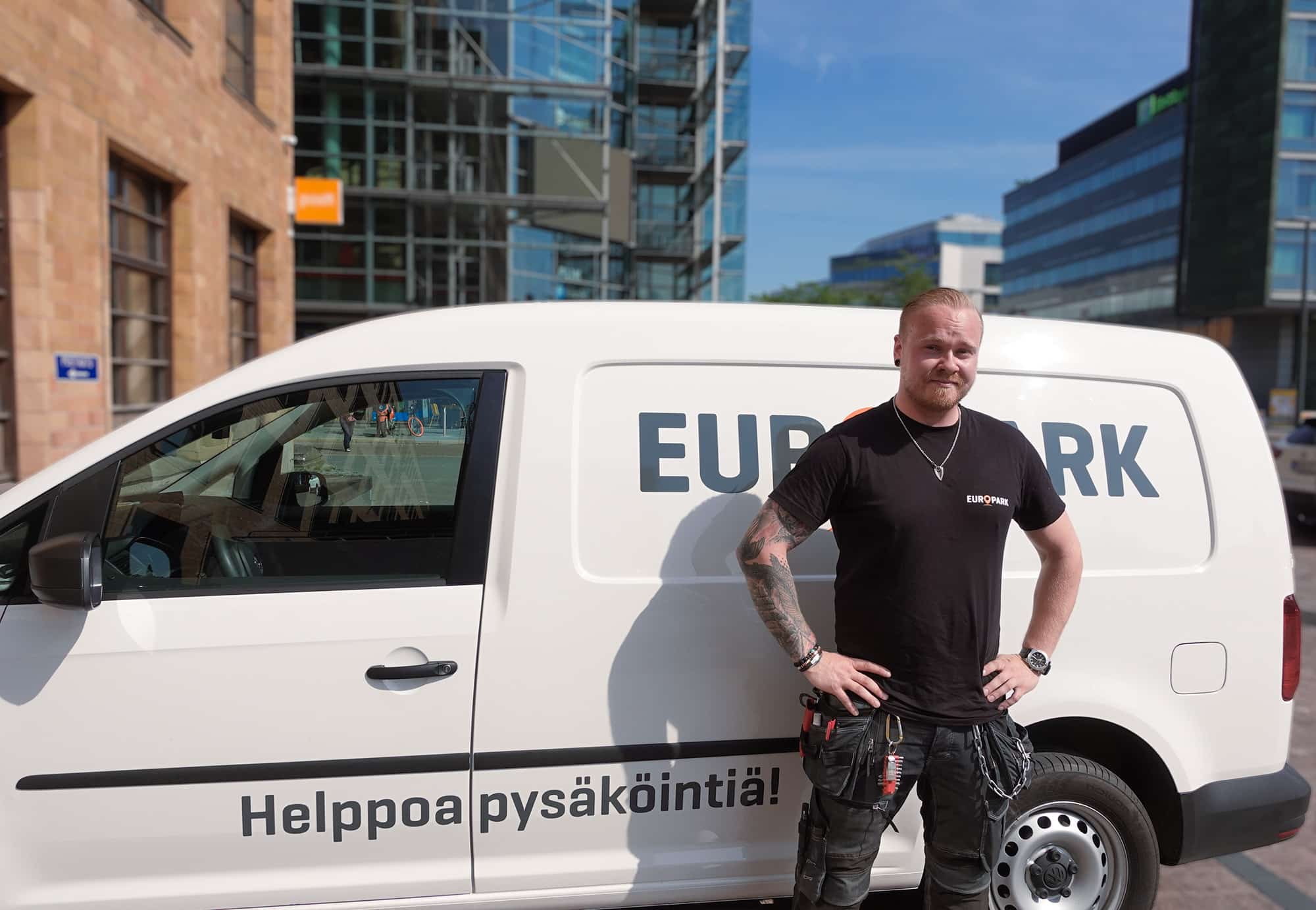 Mustiin pukeutunut henkilö nojaa EuroParkin valkoiseen pakettiautoon.